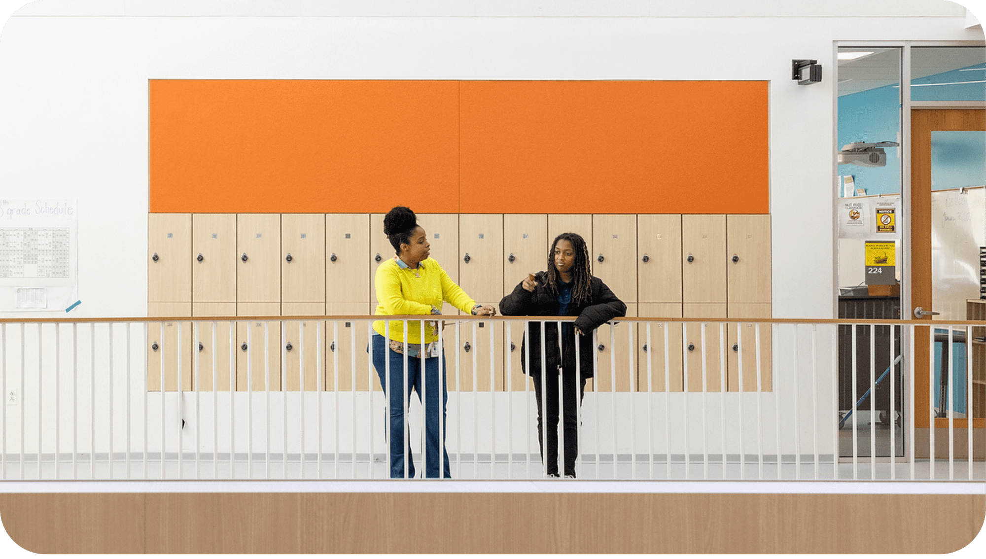 Teacher and student engaged in a conversation in the hallway