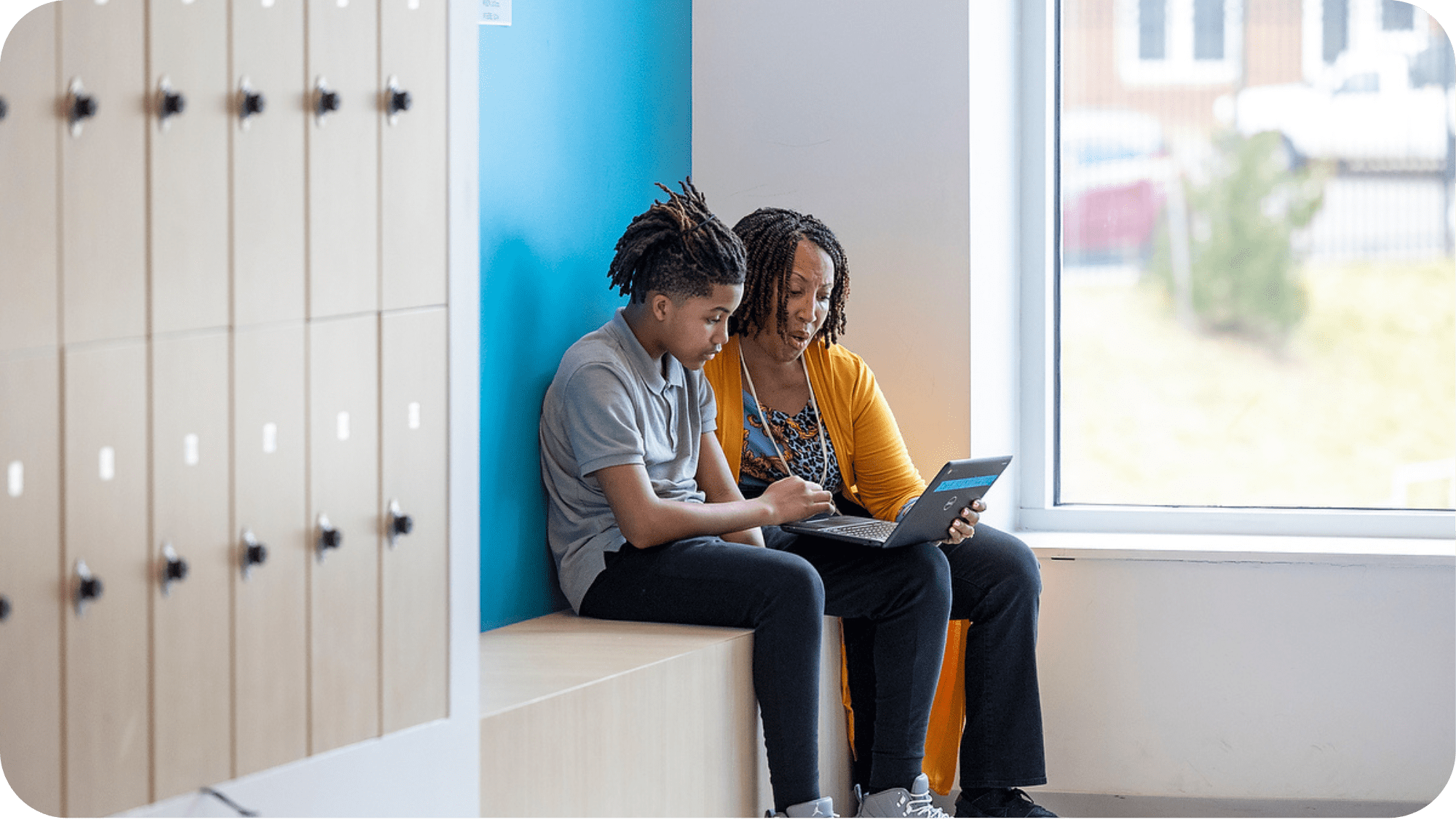 Teacher guiding a student in front of a computer during an educational session