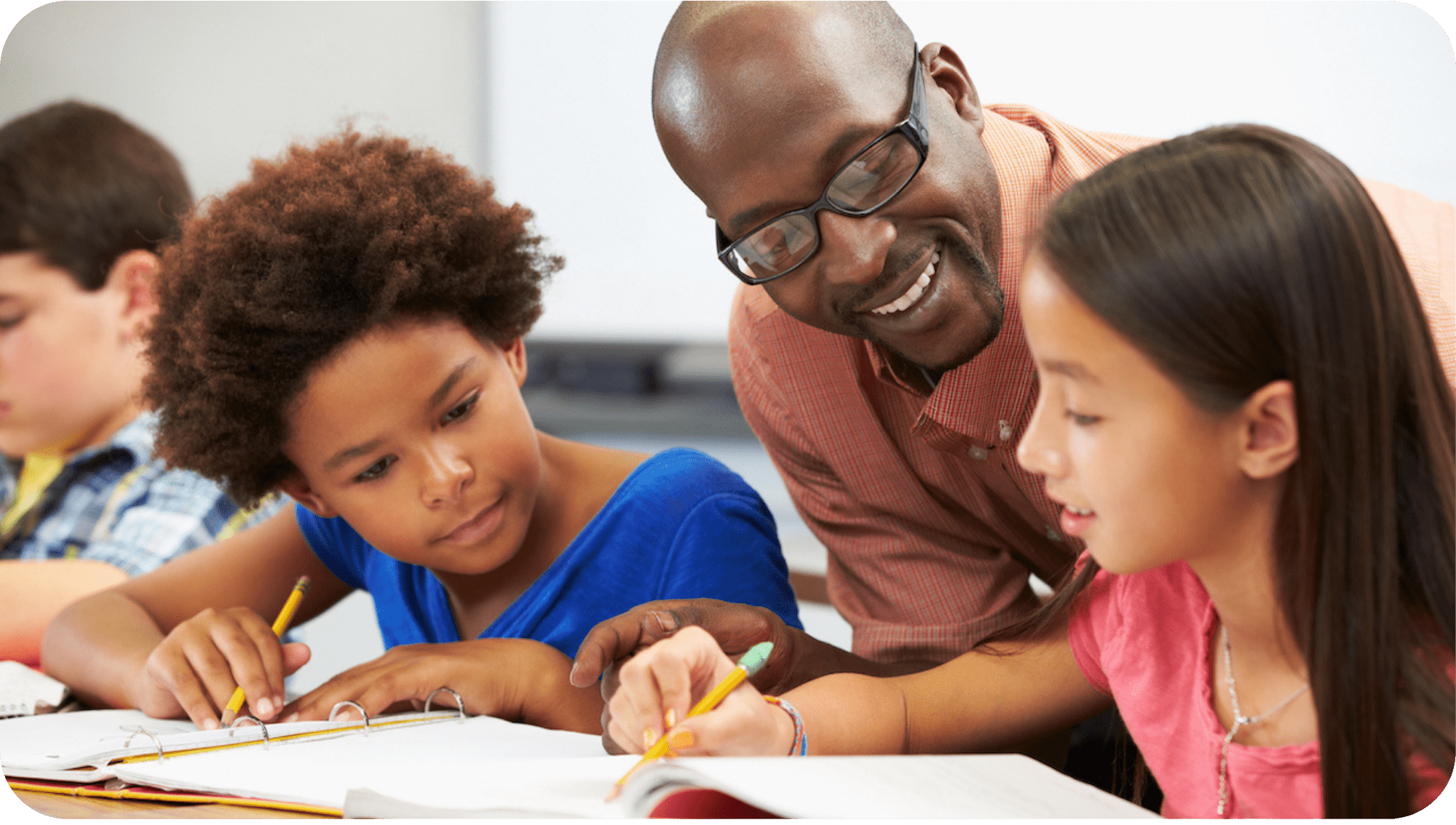 teacher helping two students with their homework